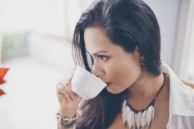 Poważne kobieta picia z kubka kawy