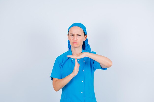 Poważnie pielęgniarka pokazuje gest ręki na białym tle