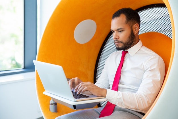 Bezpłatne zdjęcie poważny biznesmen używa laptop