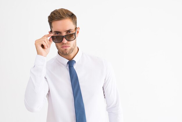 Poważny biznesowy mężczyzna patrzeje kamerę nad okularami przeciwsłonecznymi