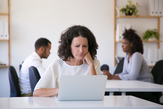 Poważny profesjonalista używa laptop w biurze