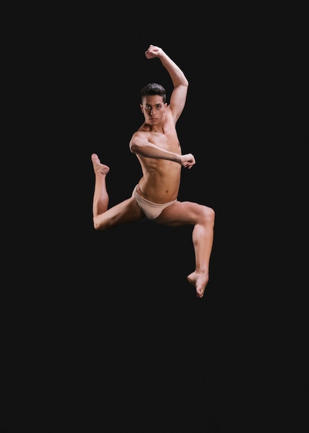Poważny tancerz skacze i patrzeje kamerę