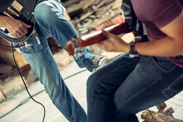 Powtórzenie zespołu rockowego. Gitarzysta elektryczny i perkusista za zestawem perkusyjnym.