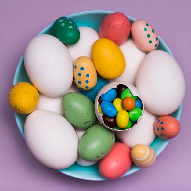 Powyżej widok dekoracji z kolorowymi jajkami i cukierkami
