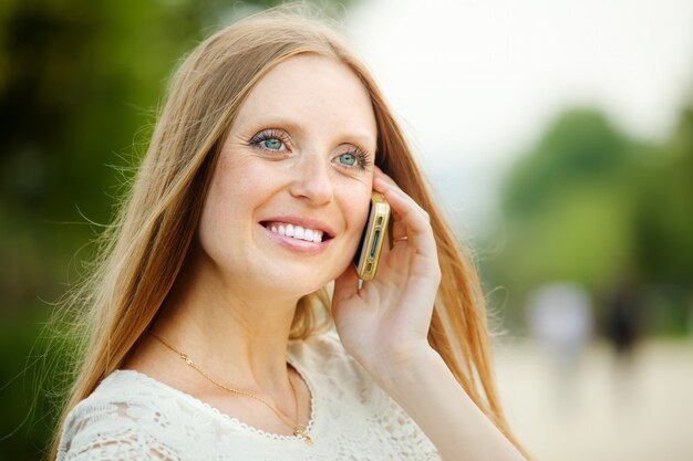 Pozytywna kobieta rozmów przez telefon komórkowy