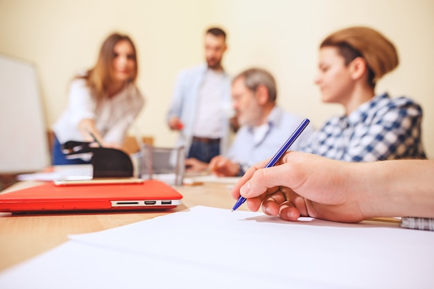 Praca zespołowa. Zdjęcie młodych biznesmenów pracujących nad nowym projektem w biurze