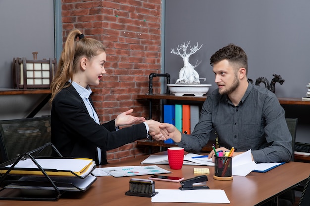 Pracowity i pewny siebie profesjonalny zespół omawiający jedną kwestię w dokumentach w urzędzie