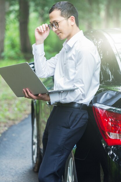 Pracownicy biznesu pracują z laptopami z boku samochodu