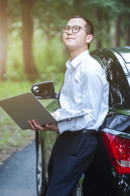 Bezpłatne zdjęcie pracownicy biznesu pracują z laptopami z boku samochodu