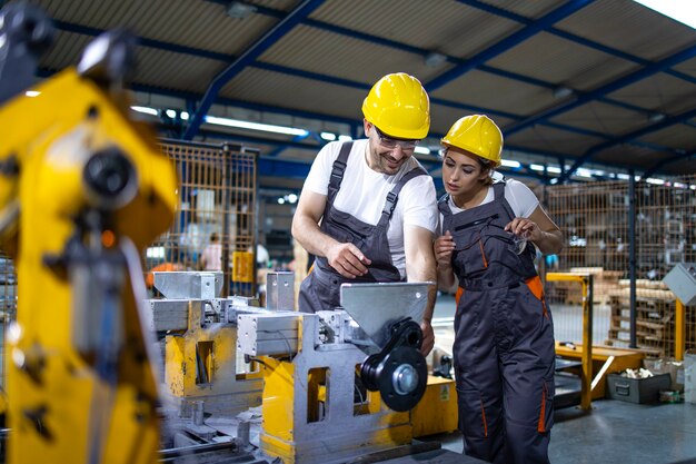 Pracownicy przemysłowi pracujący razem na linii produkcyjnej fabryki