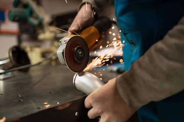 Pracownik techniczny tnący metal wieloma ostrymi iskrami Używanie sprzętu do kocia żelaza