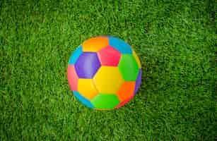 Bezpłatne zdjęcie prawdziwe skórzana kolorowe wielokolorowy piłka nożna na zielonej trawie.