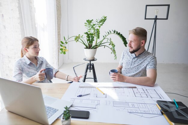 Profesjonalna architektura mężczyzn i kobiet, omawiając coś podczas przerwy na kawę