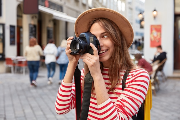 Profesjonalna fotografka używa aparatu fotograficznego do robienia zdjęć, robi zdjęcia pięknych zabytków