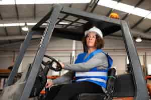 Bezpłatne zdjęcie profesjonalna kobieta-kierowca obsługująca wózek widłowy