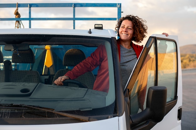 Bezpłatne zdjęcie profesjonalna kobieta-kierowca z samochodem dostawczym lub wagonowym