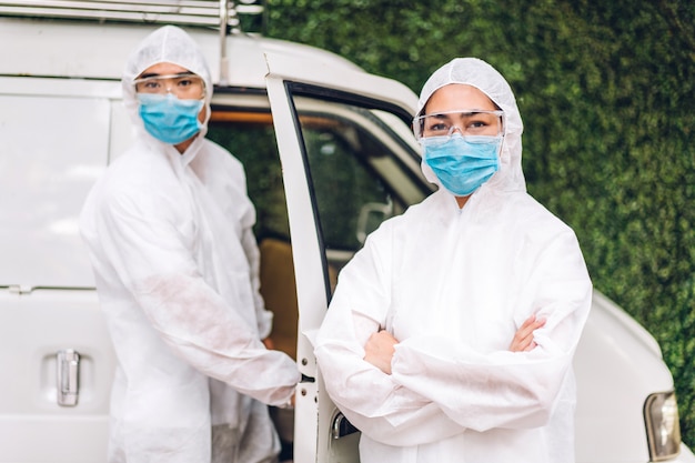 Profesjonalne zespoły do dezynfekcji pracownika w masce ochronnej i białym garniturze wirus dezynfekujący spray do czyszczenia w celu pomocy w zabiciu koronawirusa w domu klienta