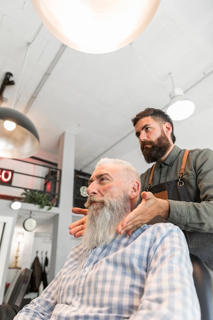 Profesjonalny fryzjer skończył pielęgnować długą siwą brodę