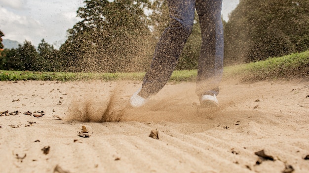 Bezpłatne zdjęcie profesjonalny golfista. uderza piłkę z łapacza piasku. bali. inodesia.