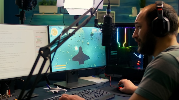 Profesjonalny streamer grający w kosmiczne strzelanki podczas zawodów online przy użyciu profesjonalnej konfiguracji z otwartym czatem