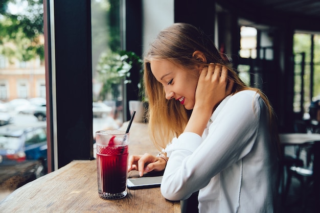 Bezpłatne zdjęcie profil uśmiechnięta młoda blondynki kobieta, używać smartphone, texting wiadomość