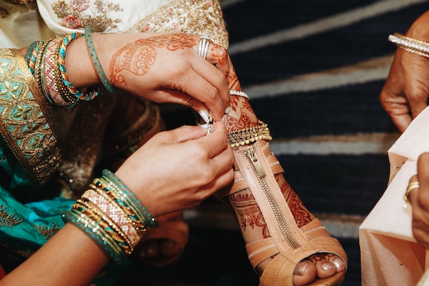 Przebieranie butów dla indyjskiej panny młodej przed ślubem