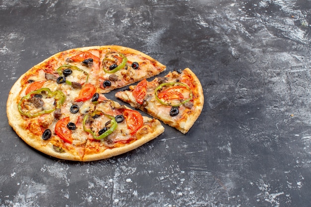 Przedni widok pyszna pizza z serem pocięta na plasterki i podawana na szarej powierzchni