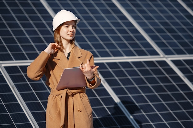 Przedsiębiorców pracujących nad sprawdzaniem sprzętu w elektrowni słonecznej. Z listą kontrolną tabletu, kobieta pracująca na zewnątrz na energię słoneczną.