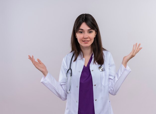 Przekonana, młoda kobieta lekarz w szlafroku ze stetoskopem trzyma ręce na na białym tle z miejsca na kopię