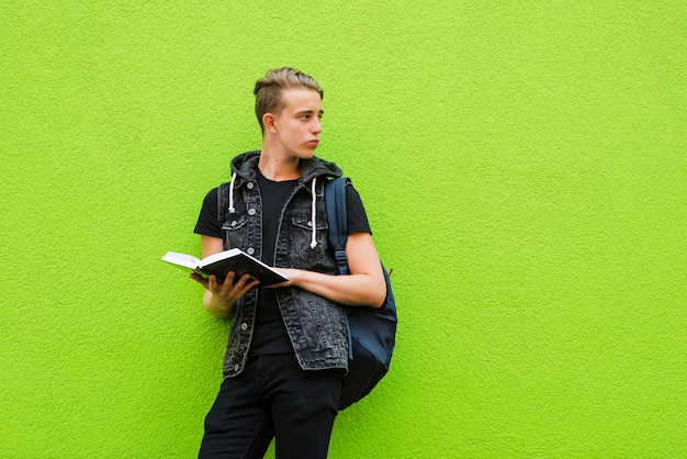 Bezpłatne zdjęcie przemyślany student posing z książki