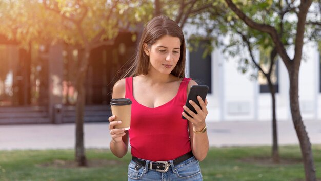 Przeszukuje telefon komórkowy całkiem młoda kobieta