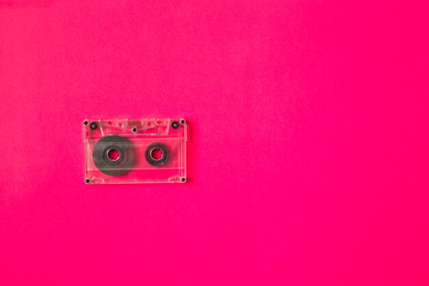 Przezroczysta kaseta magnetofonowa na różowym tle