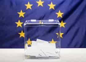 Bezpłatne zdjęcie przezroczysta urna wypełniona białą kopertą i flagą unii europejskiej