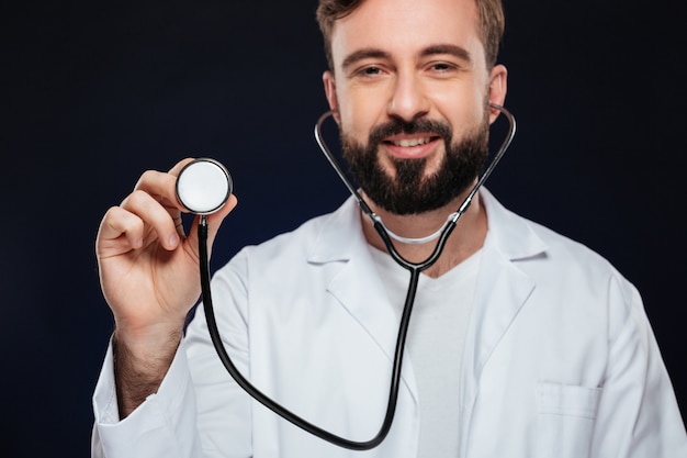 Przycięty obraz szczęśliwego lekarza płci męskiej ubranego w mundurze