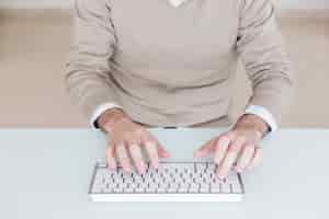 Bezpłatne zdjęcie przycinaj człowieka za pomocą klawiatury komputera