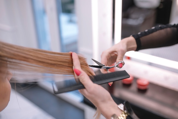Bezpłatne zdjęcie przycinanie stylistów do przycinania końcówek włosów w salonie
