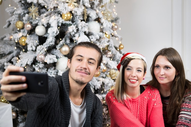 Bezpłatne zdjęcie przyjaciele bierze selfie przed choinką