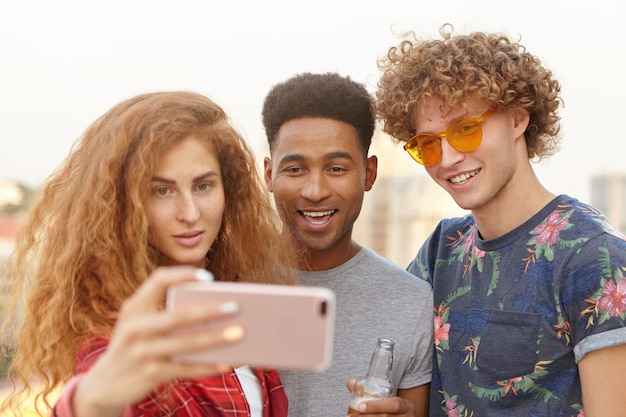 przyjaciele biorący selfie za pomocą telefonu komórkowego