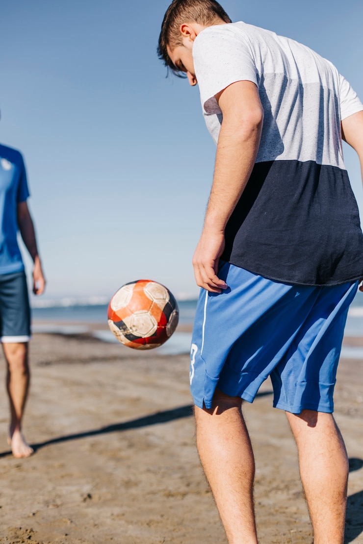 Bezpłatny plik Zdjęcie przyjaciele grają w piłkę nożną na plaży