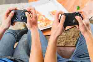 Bezpłatne zdjęcie przyjaciele jedzą pizzę i grają na konsoli