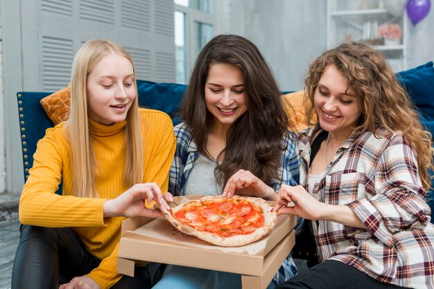 Przyjaciele jedzą pizzę