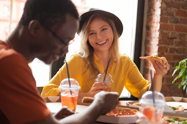 Przyjaciele jedzący pizzę średni strzał