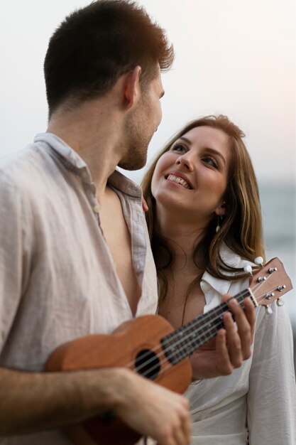 Przyjaciele na imprezie na plaży z ukulele