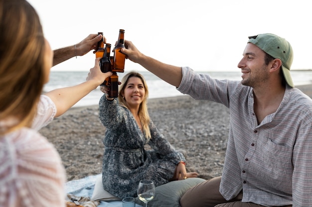 Przyjaciele na plaży z butelkami piwa