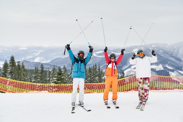 Przyjaciele narciarzy bawią się w ośrodku narciarskim w górach zimą na nartach i snowboardzie