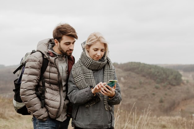 Przyjaciele patrzeje telefon outdoors