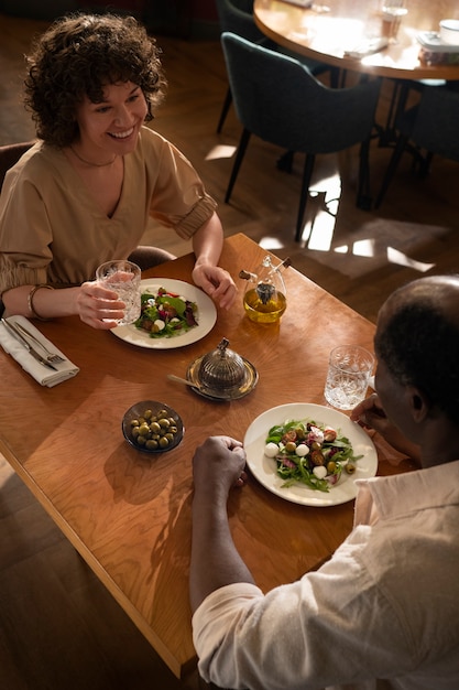 Przyjaciele pod dużym kątem jedzący w restauracji