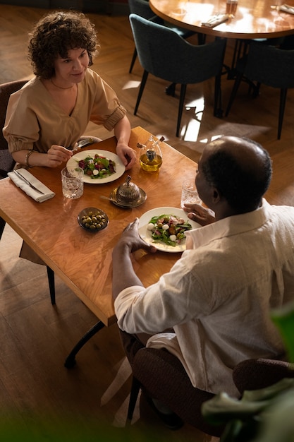 Bezpłatne zdjęcie przyjaciele pod dużym kątem jedzący w restauracji