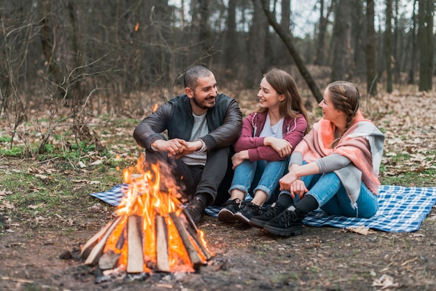 Przyjaciele pod dużym kątem rozmawiają przy ognisku