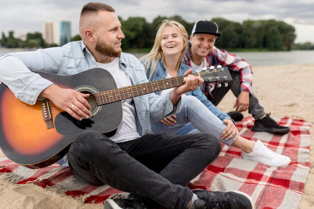 Przyjaciele śpiewają i grają na gitarze na zewnątrz